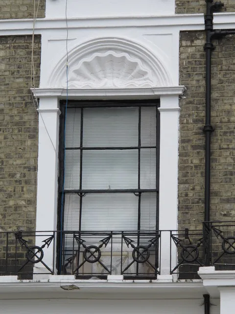 Sash window, brickwork and decorative plaster detail on a terrace in Belsize Road, London
