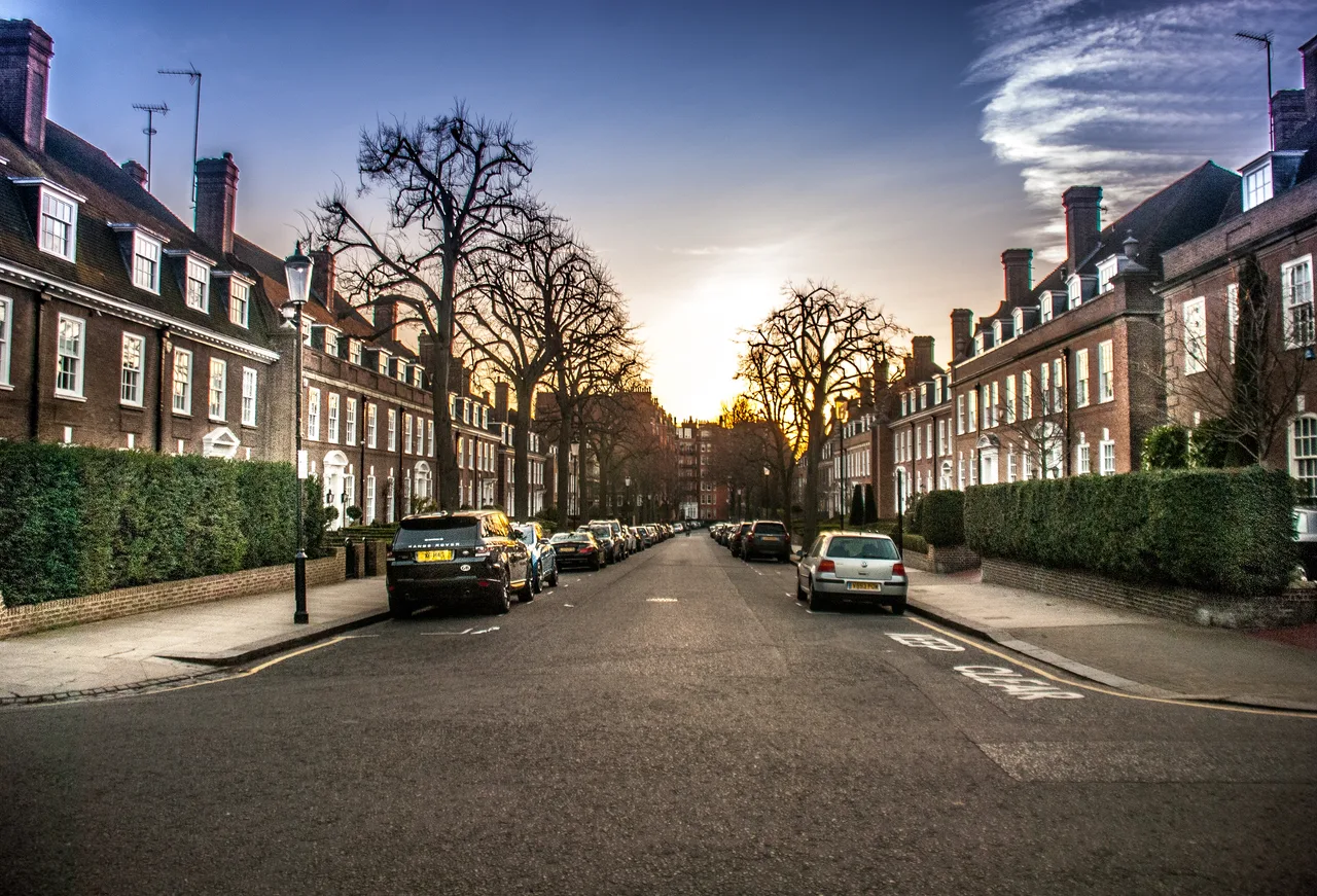 A residential street lined with brick terraced houses in Kensington, London